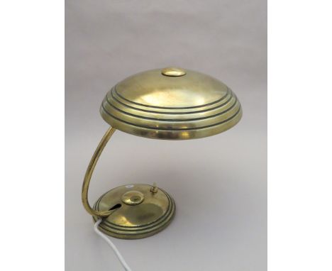 A hooded brass coloured desk lamp 