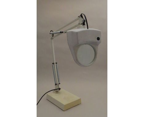 A 1970's angle poise style desk lamp fitted with a magnifying glass 
