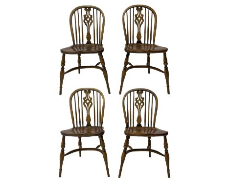 Set of four elm Windsor dining chairs, high hoop and stick back with shaped pierced splat, over shaped saddle seat, raised on