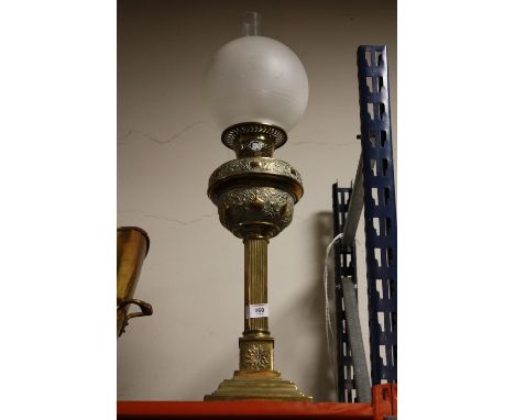 AN ORNATE BRASS COLUMN OIL LAMP WITH SHADE AND FLUE