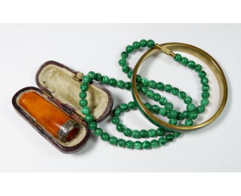 A malachite bead necklace and bangle and a silver mounted amber cigarette holder 