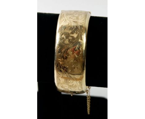 A 9ct gold hinged and engraved bangle, 33gm 
