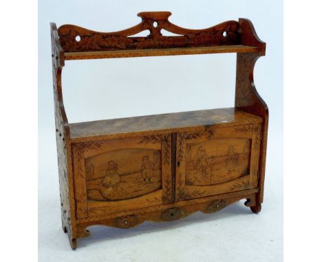 An Edwardian wall shelf and cupboard with all over inlaid decoration of Dutch children, flowers and beasts, 58cm wide 