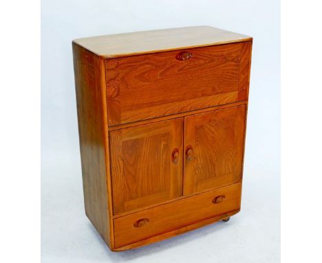 An Ercol light elm cabinet with drop front over cupboard and drawer 