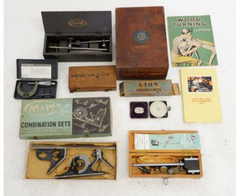 A box containing various woodworking tools including Moore and Wright combination sets, adjustable slips, a Fowler calculator
