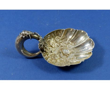 A silver caddy spoon Birmingham 1865 by George Unite with embossed floral and shell bowl and vines to stem 