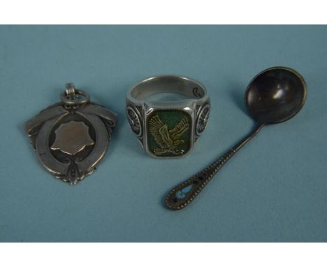 Three pieces of silver including a fob, a ring with eagle decoration and a salt spoon (possibly Russian)