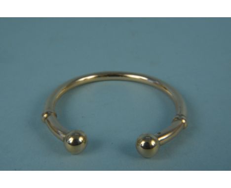 An unmarked yellow metal torque style bangle (slightly misshapen), weight approx 10g