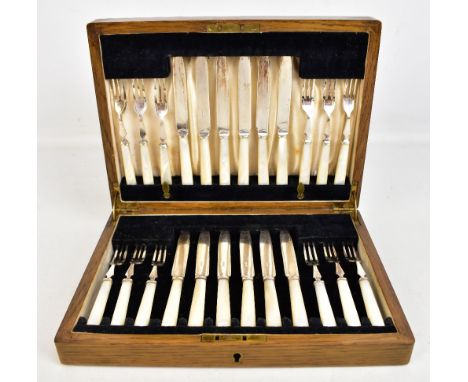 An oak cased set of twelve mother of pearl handled and silver plate bladed fruit knives and forks.Additional InformationSome 