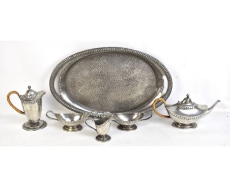 TUDRIC PEWTER FOR LIBERTY &amp; CO; a six piece hammered pewter tea service and twin handled tray, impressed marks and No.010