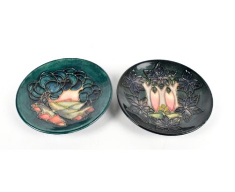 MOORCROFT; two tube line decorated pin dishes on green grounds, both with impressed marks to bases, diameter 11.7cm (2).Addit