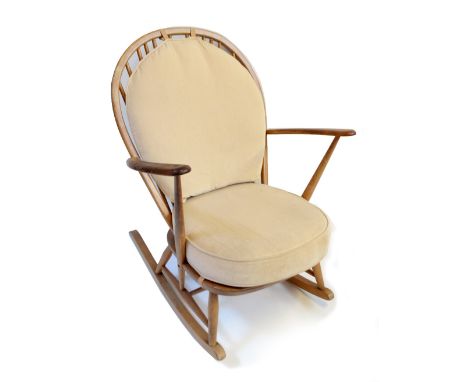ERCOL; a light elm spindle back rocking chair.Additional InformationHeavy wear, splitting to the top rail, water damage, a co