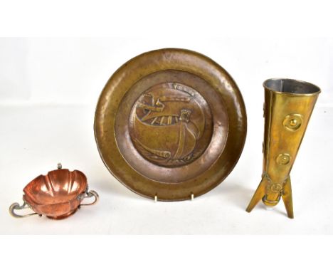 An Arts &amp; Crafts brass charger with embossed detail depicting a long boat, diameter 32.5cm, a copper bowl probably by A.E