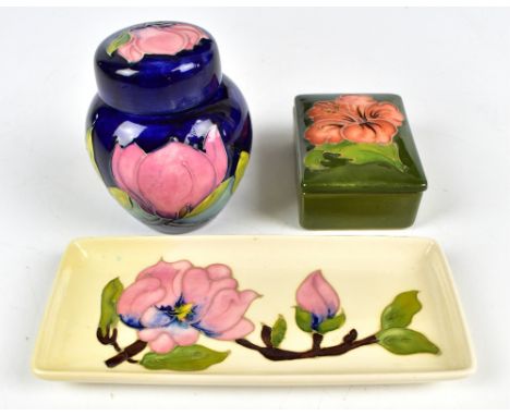 MOORCROFT; a ginger jar and cover decorated in the Magnolia pattern on a blue ground, height 11cm, a lidded trinket box decor
