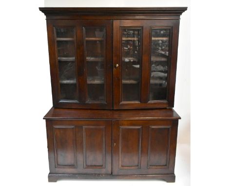 A large early 20th century stained pine school cabinet, the upper section with moulded cornice above four glazed doors, the b