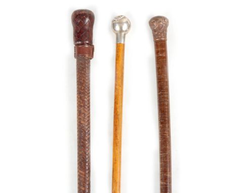 A COLLECTION OF THREE WALKING STICK comprising of a leather-bound walking stick/cosh with weighted handle, another leather bo