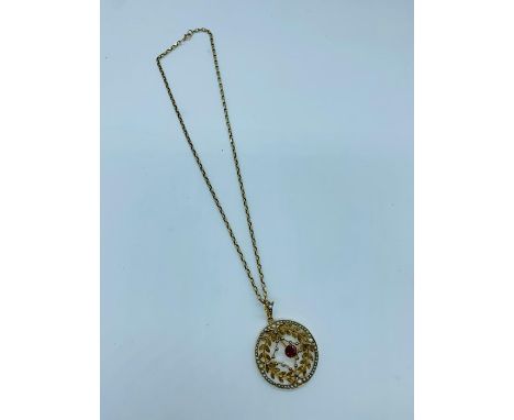 A 9ct gold pendant with central ruby and a ring of seed pearls
