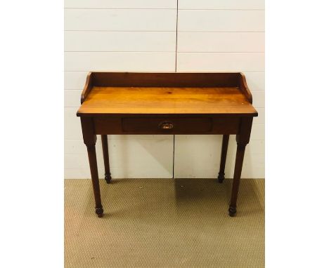 A hall desk/console with drawer, brass cup handles and turned legs 