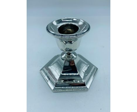 A silver candlestick of squat design, hallmarked Chester 1911-1912