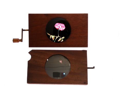 Mahogany-mounted Magic Lantern Slides: rotary opening flower slide, hand painted, G, and rotating and slipper slide of bonfir