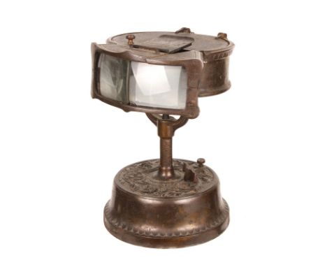 A Clockwork Kinora Viewer, cast metal body with hinged top and two viewing lenses, mounted upon an ornate base containing the