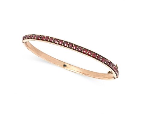 AN ANTIQUE BOHEMIAN GARNET BANGLE in silver gilt, set all round with a row of rose cut garnets, no assay marks, inner circumf