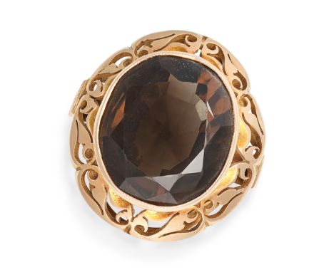 A SMOKEY QUARTZ COCKTAIL RING in 14ct yellow gold, set an oval cut smokey quartz in a scrolling openwork border, Polish assay