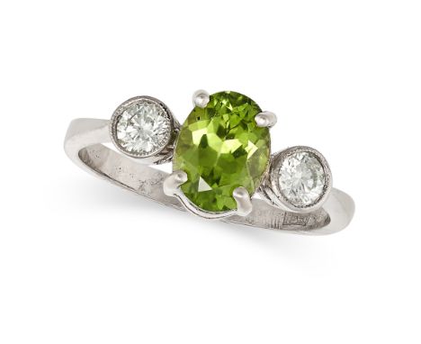 A PERIDOT AND DIAMOND THREE STONE RING in 18ct white gold, set with an oval cut peridot of approximately 1.49 carats between 