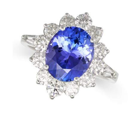 A TANZANITE AND DIAMOND CLUSTER RING in 18ct white gold, set with an oval cut tanzanite of 3.56 carats in a cluster of round 