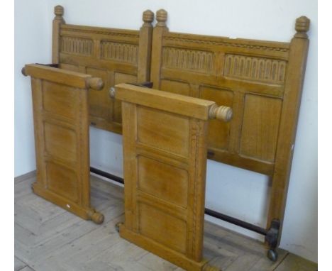 Pair 20th Century Jacobean style light oak single bedsteads with carved and panel head and foot-boards 