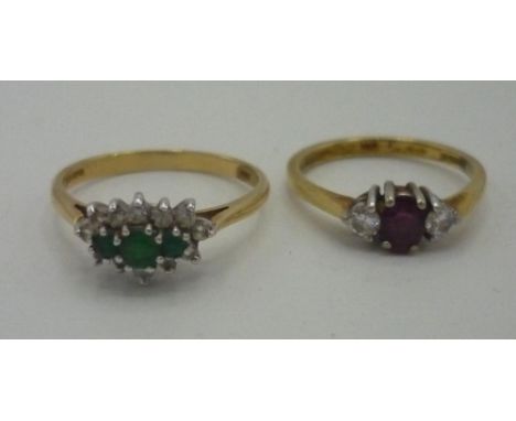 An 18ct gold ring set with emeralds and diamonds, and a diamond and ruby trilogy ring, both hallmarked .750 (2) 