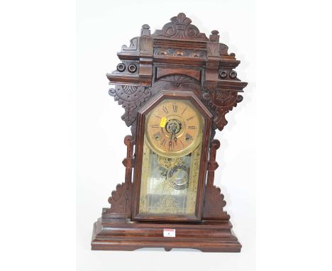 An early 20th century gingerbread type mantel clock, the chapter ring showing Roman numerals, having eight-day movement strik