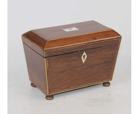 An early 19th century partridge wood and boxwood strung tea caddy, of sarcophagus form, the hinged lid lifting to reveal a fi