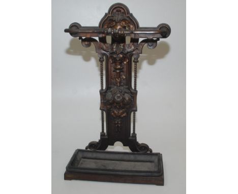A Victorian iron stick stand cast with the head of a woman above leaves and fruit, height 73cm, old repair.