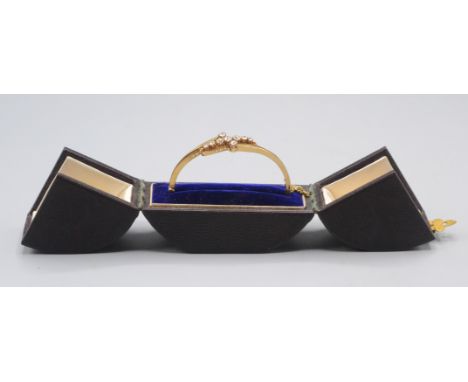 A good Goldsmiths &amp; Silversmiths Company 18ct gold hinged bangle set with a crossover arrangement of nine diamonds 12g, i