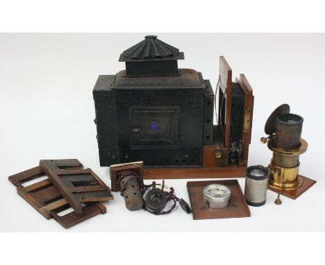 A Victorian black painted metal magic lantern, with brass lens, in a wooden case, length 55cm.