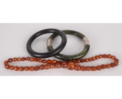 Two 'jade' bangles and a faceted 'amber' bead necklace.