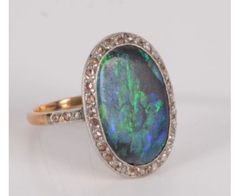 An opal and diamond oval cluster ring.   Condition report:  Solid opal, natural fault on back of opal, small chip near mount.