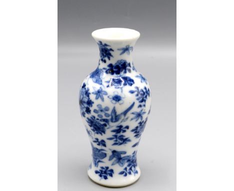 A Chinese blue and white baluster vase decorated with floral sprays and birds in flight, four character Kangxi mark to base, 