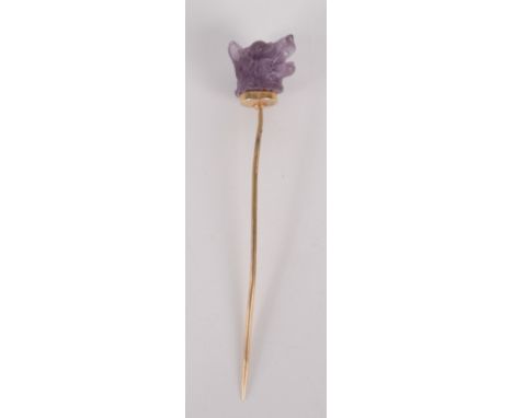 A stick pin with amethyst glass dog finial.