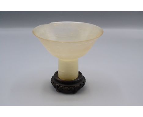 A Chinese translucent pale celadon jade Ming style stem cup, 19th century, the eggshell thin wide conical body of plain but e