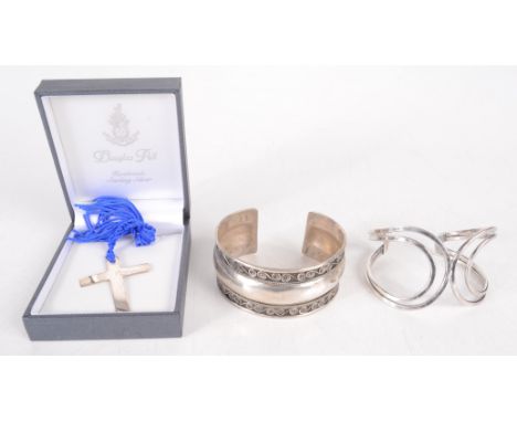 A silver cross, a Mexican silver bangle and one other silver cuff bangle.