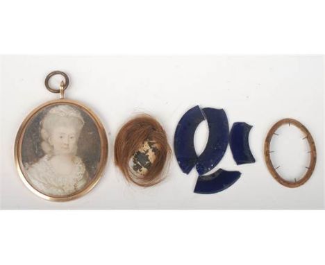 A George III portrait miniature of a lady, her hair beneath a lace cap, gold pendant mount  6 x 4.8cm. Damage to the memoriam