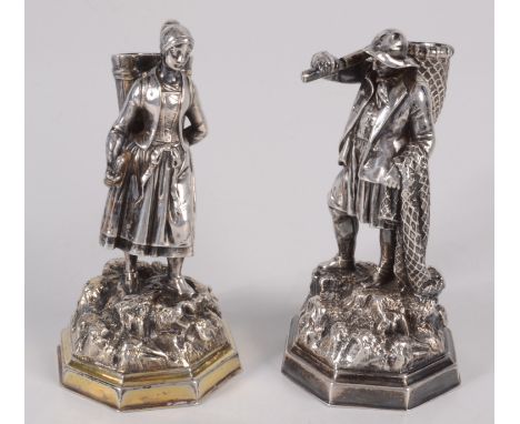 A pair of Russian silver figures, one is of a woman, she carries a hopper on her back, he stands with a net over one arm, and
