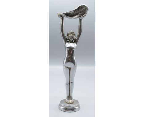 A chrome car mascot of a nude lady holding aloft a feather on a circular plinth, height 24.7cm.