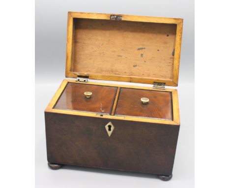 A mahogany tea caddy, early 19th century, the hinged lid opening to reveal  twin compartments, the covers with turned ivory h