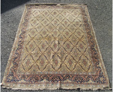 An Indian carpet, the ivory field with an all over trellis design enclosing small medallions within an indigo stylised plant 