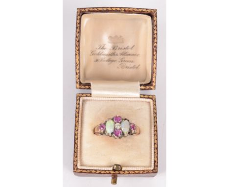 A 9ct gold ring set an opal and red stone cluster.