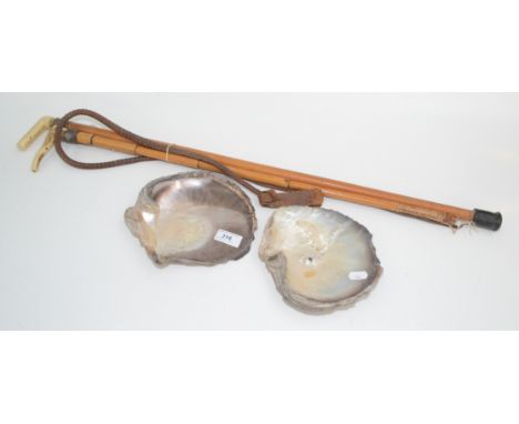 A hunting crop, a walking stick and two shells. 