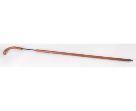 A sword stick, in the form of a wooden walking stick, the blade engraved with gilt decorated floral sprays and indistinct num
